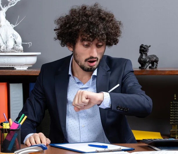 An employee late for scheduled work watching time on his wrist watch